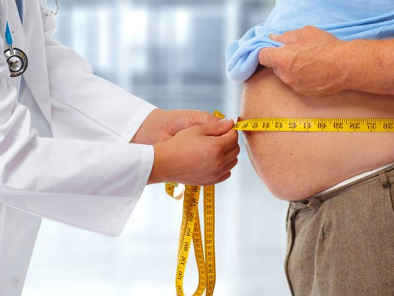 medico medido a cintura de um homem com fita metrica